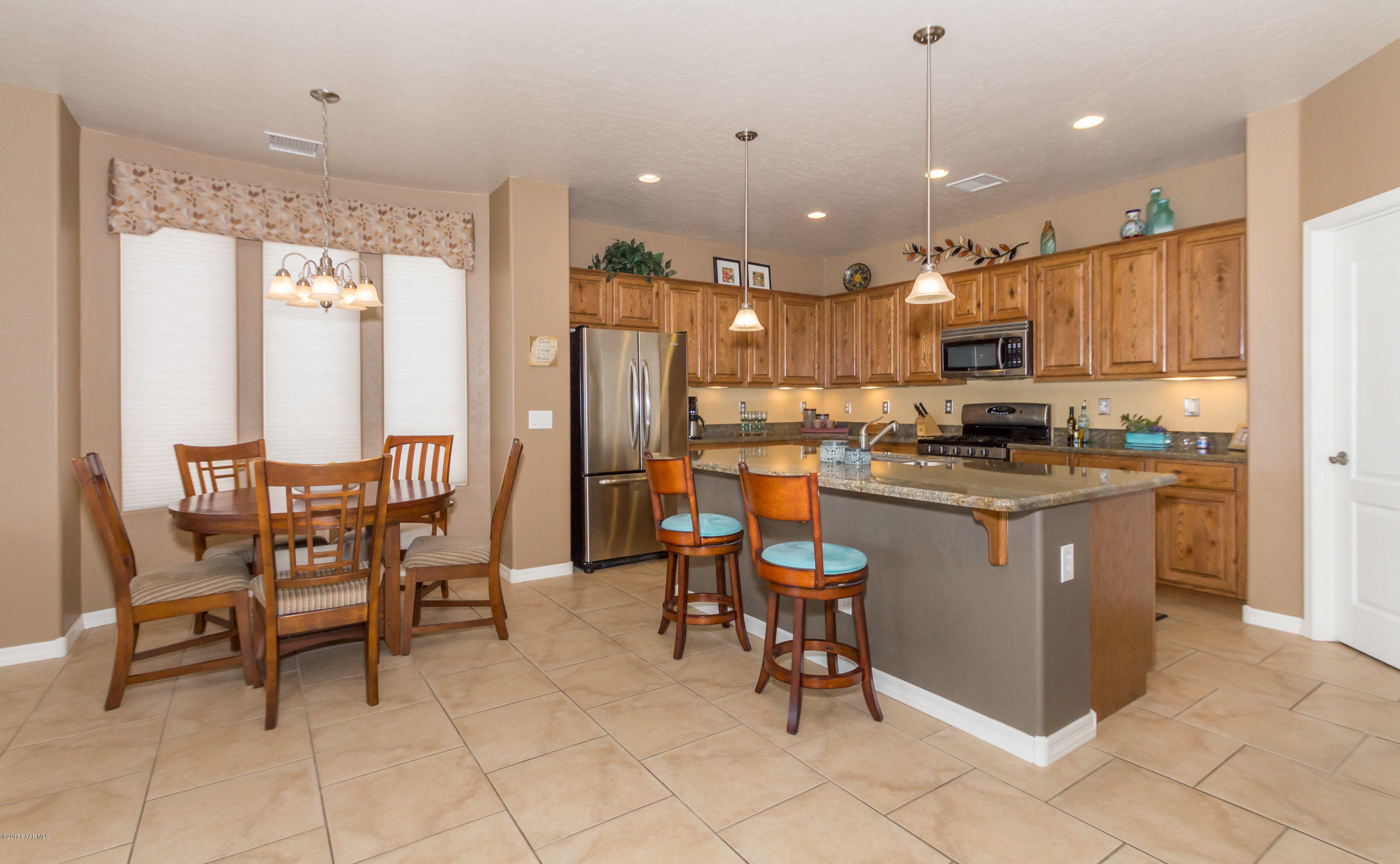 1197 Rusty Nail Road Prescott Valley, AZ 86314 - Photo 7 of 40 a kitchen with a refrigerator a dining table and chairs