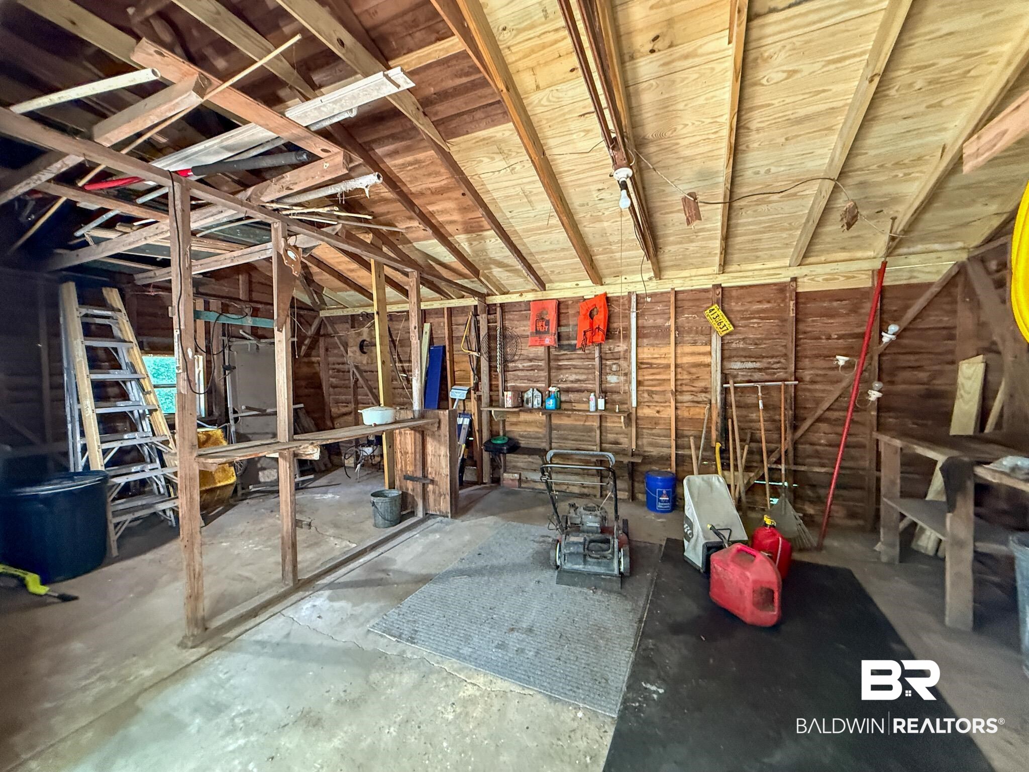 18711 Keller Road Foley, AL 36535 - Photo 36 of 38 Spacious interior featuring exposed wood-plank walls and ceiling, concrete flooring, and built-in shelving