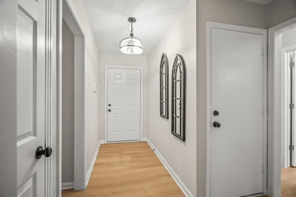 a view of a hallway with wooden floor and closet
