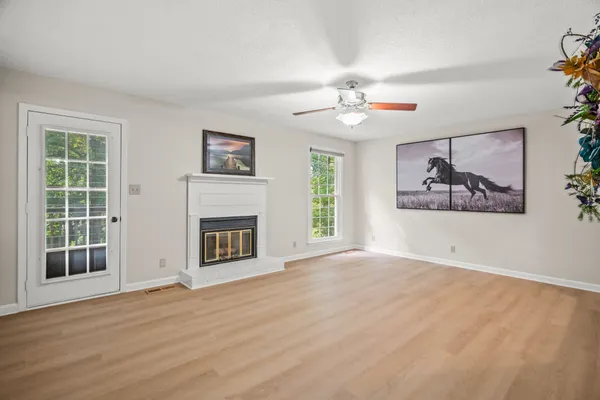 a view of an empty room with a fireplace and a window