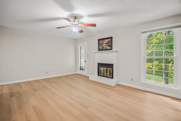 a view of an empty room with a fireplace and a window