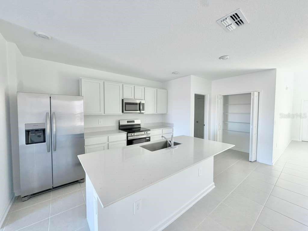 2764 Lookout Rdg Road Haines City, FL 33844 - Photo 5 of 21 a kitchen with stainless steel appliances a refrigerator sink and stove