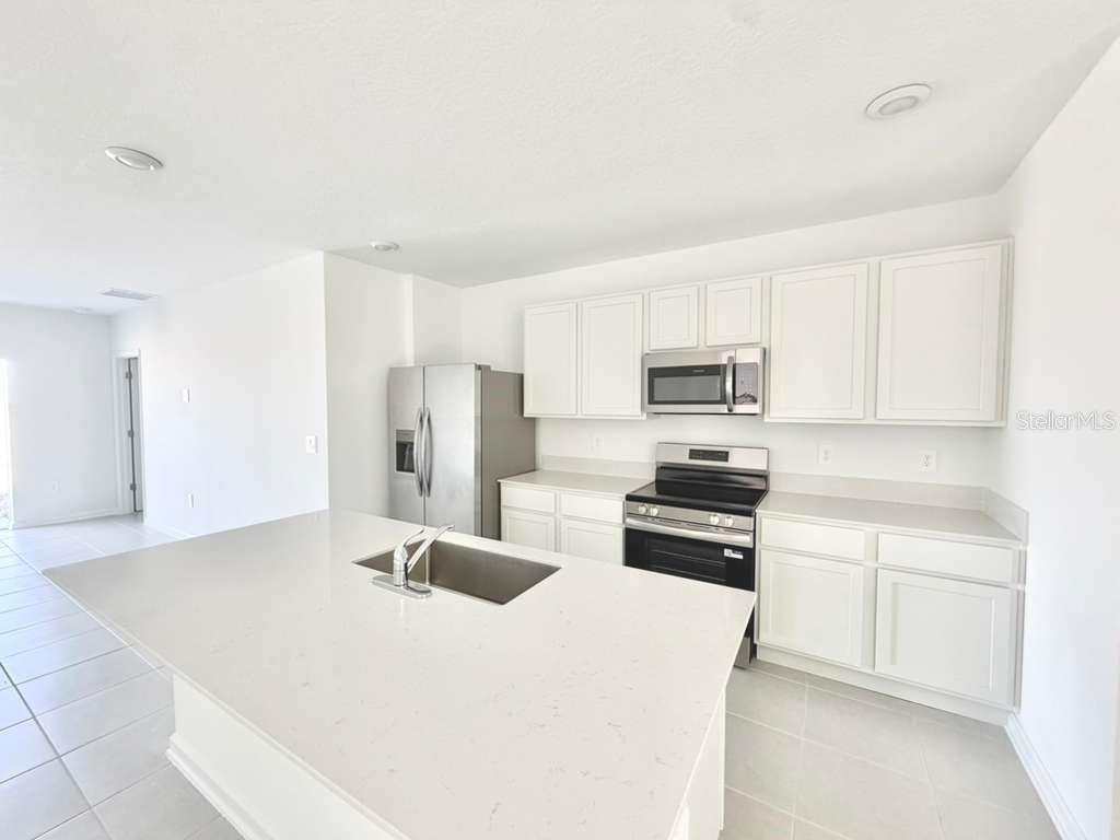 2764 Lookout Rdg Road Haines City, FL 33844 - Photo 7 of 21 a kitchen with stainless steel appliances a refrigerator sink and white cabinets