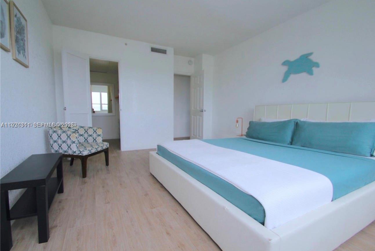 1500 Bay Road, Unit 374S Miami Beach, FL 33139 - Photo 13 of 33 a bedroom with a bed and a table in it