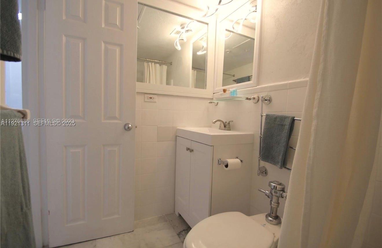 1500 Bay Road, Unit 374S Miami Beach, FL 33139 - Photo 19 of 33 a bathroom with a toilet sink and mirror