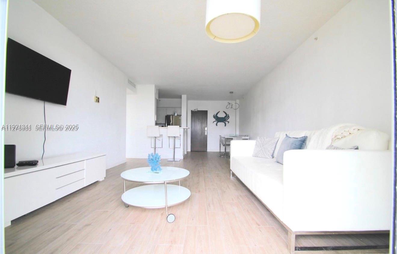 1500 Bay Road, Unit 374S Miami Beach, FL 33139 - Photo 4 of 33 a living room with furniture and a flat screen tv