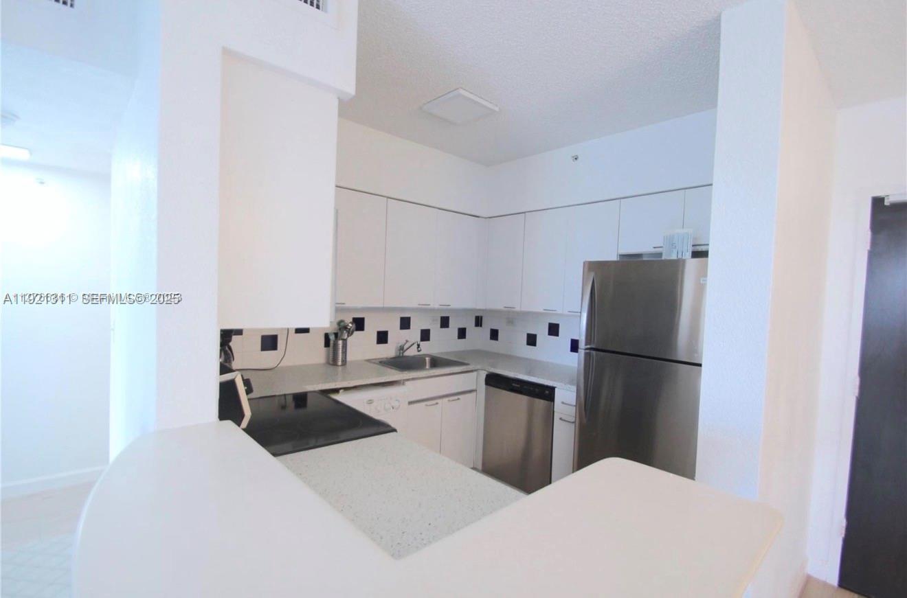 1500 Bay Road, Unit 374S Miami Beach, FL 33139 - Photo 6 of 33 a kitchen with a refrigerator and a stove
