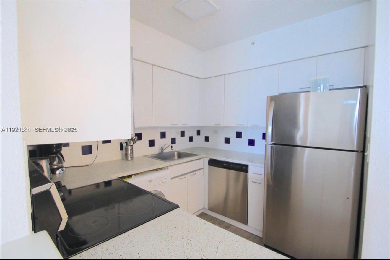 1500 Bay Road, Unit 374S Miami Beach, FL 33139 - Photo 7 of 33 a kitchen with stainless steel appliances a refrigerator sink and cabinets