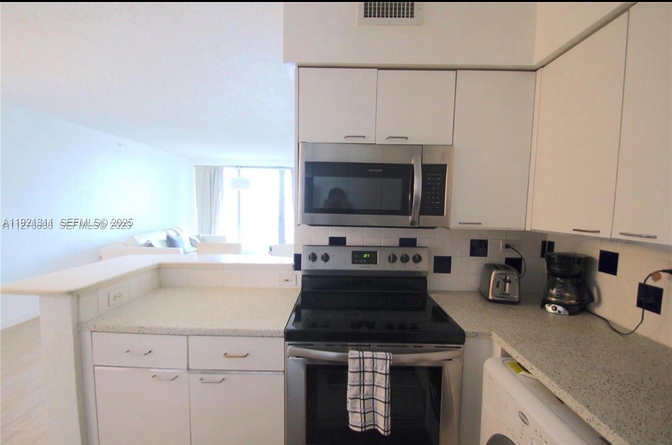 1500 Bay Road, Unit 374S Miami Beach, FL 33139 - Photo 10 of 33 a kitchen with a sink and a stove top oven