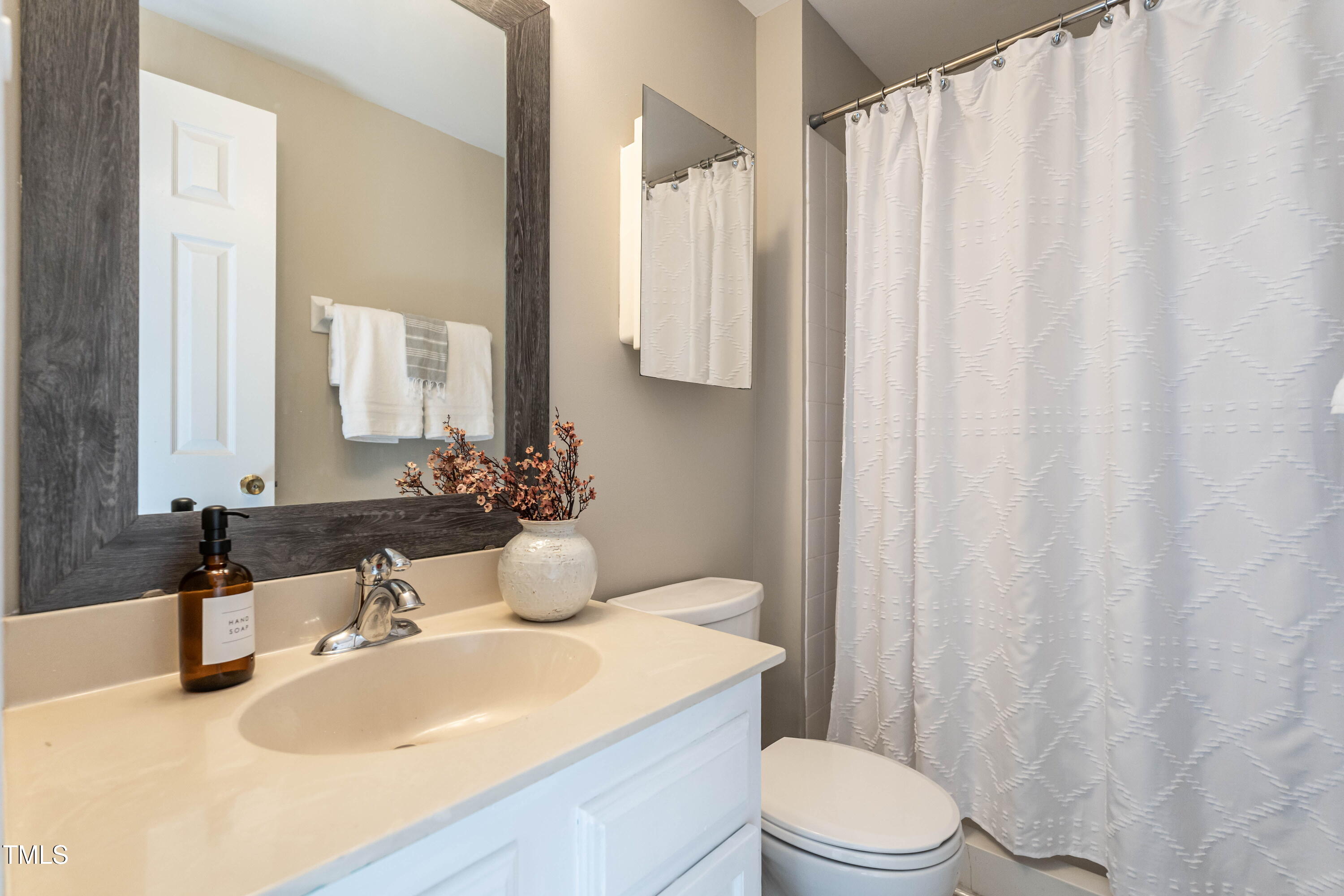 1001 Whetstone Court Raleigh, NC 27615 - Photo 21 of 31 a bathroom with a sink a toilet and shower curtain