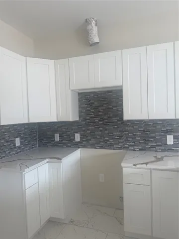 a kitchen with granite countertop white cabinets and white appliances