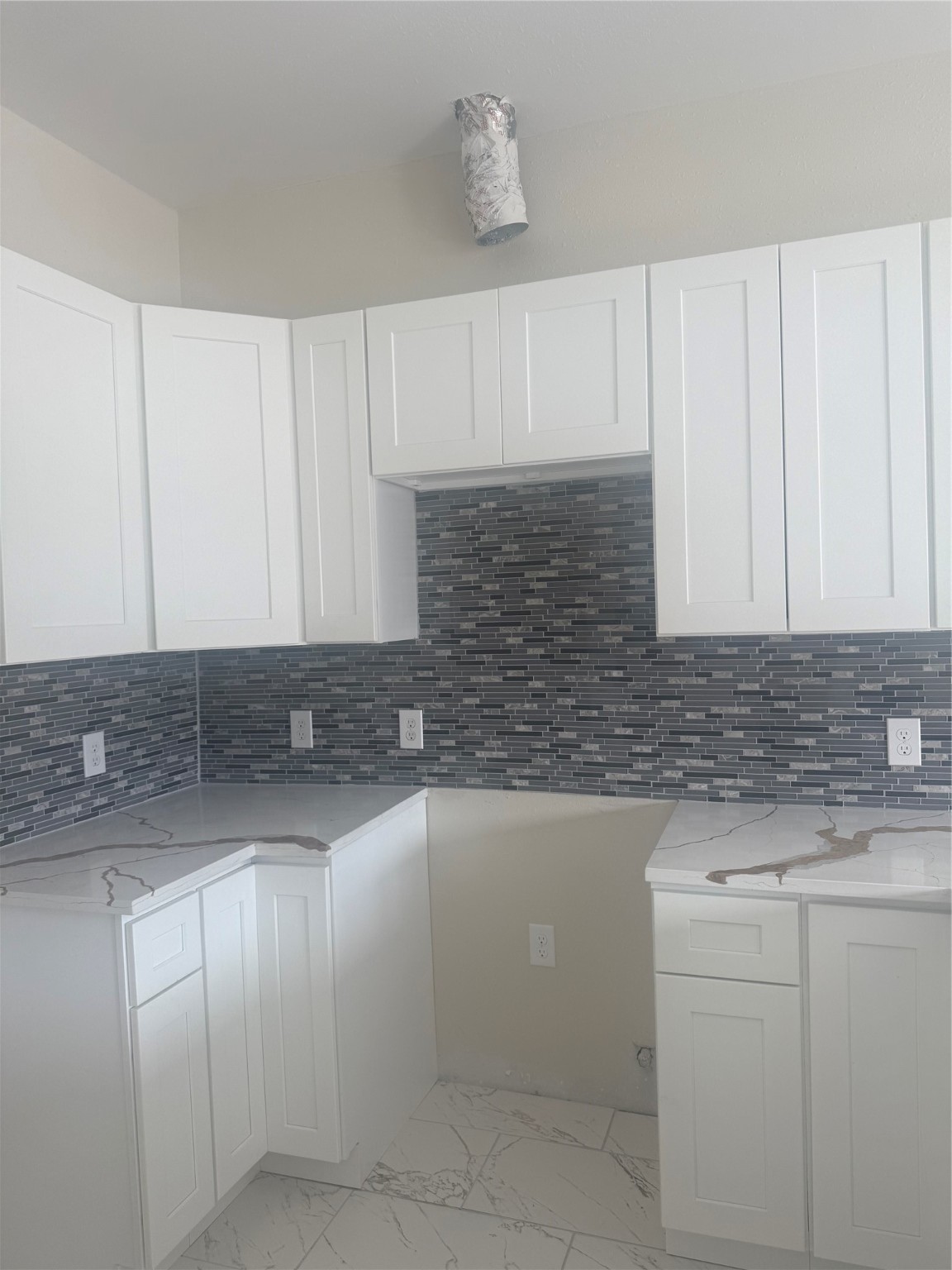 a kitchen with granite countertop white cabinets and white appliances