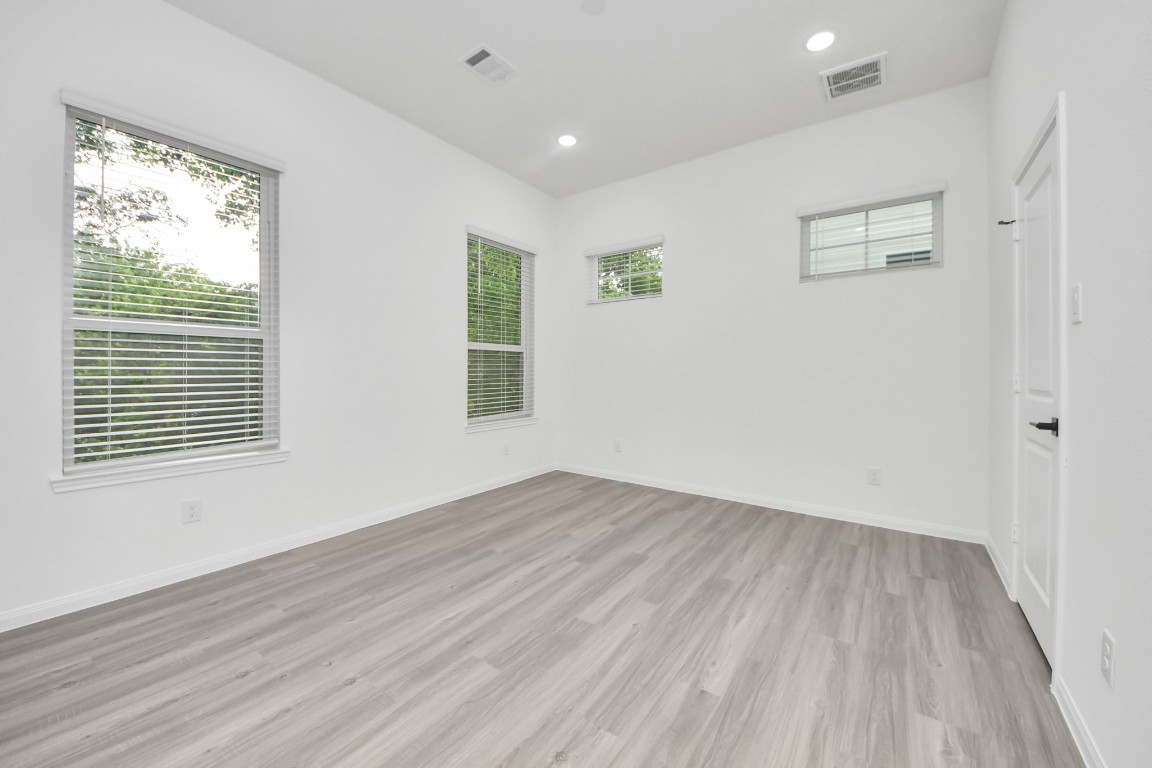 5103 Mallow Street, Unit B Houston, TX 77033 - Photo 16 of 30 an empty room with wooden floor and windows