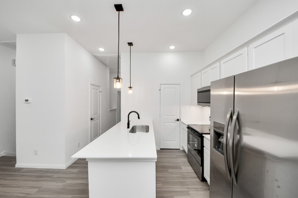 5103 Mallow Street, Unit B Houston, TX 77033 - Photo 8 of 30 a kitchen with stainless steel appliances a refrigerator a sink a counter space and wooden floor