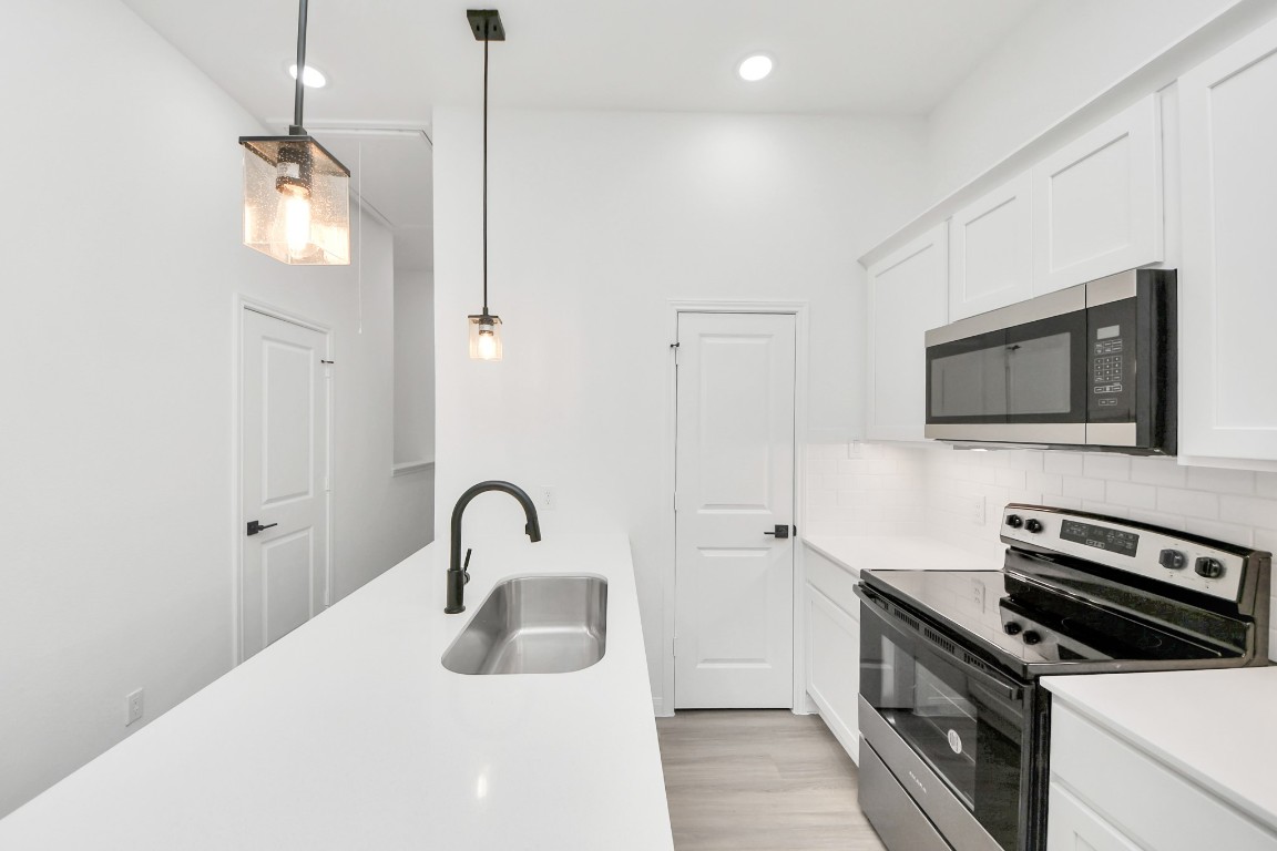 5103 Mallow Street, Unit B Houston, TX 77033 - Photo 9 of 30 a kitchen with a sink and a stove top oven