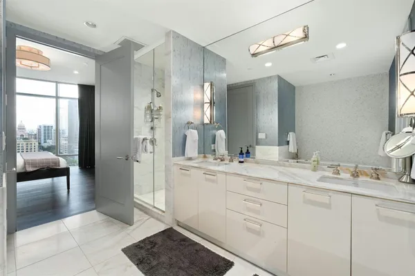 a spacious bathroom with a shower a sink and a mirror