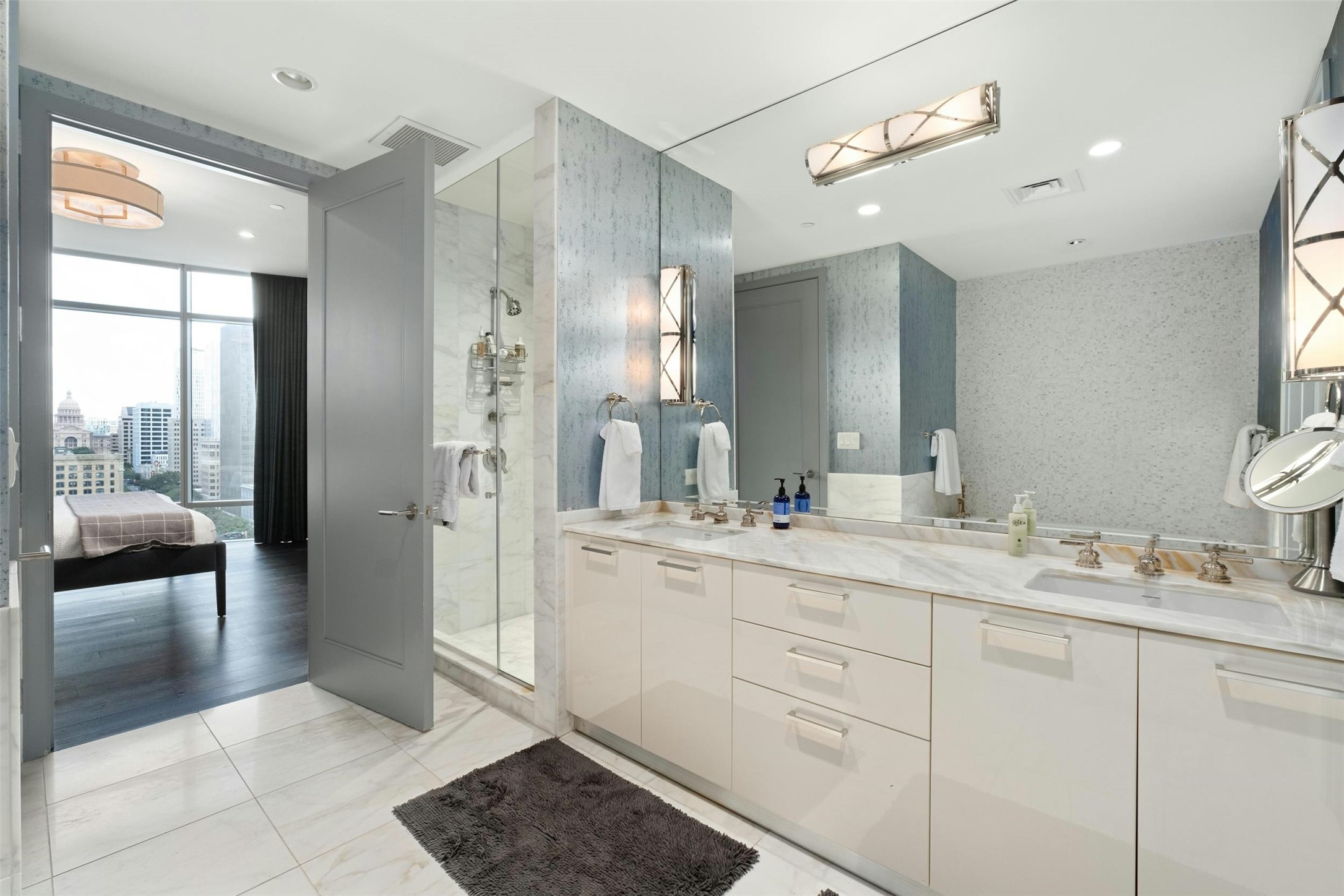 200 Congress Avenue, Unit 15D Austin, TX 78701 - Photo 13 of 23 a spacious bathroom with a shower a sink and a mirror
