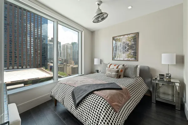 a bedroom with a large bed and a lamp on table