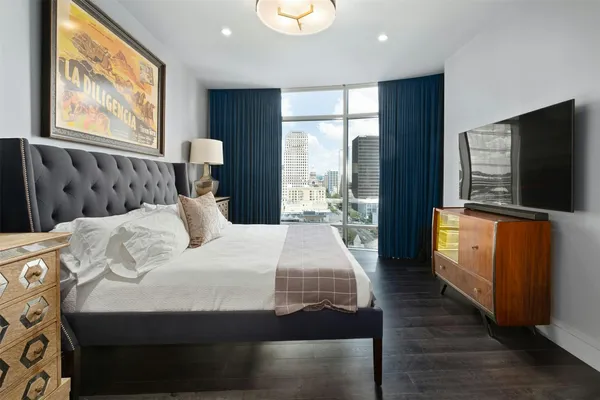 a bedroom with a bed and a flat tv screen on dresser