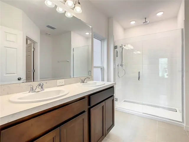 a bathroom with a double vanity sink mirror double and shower