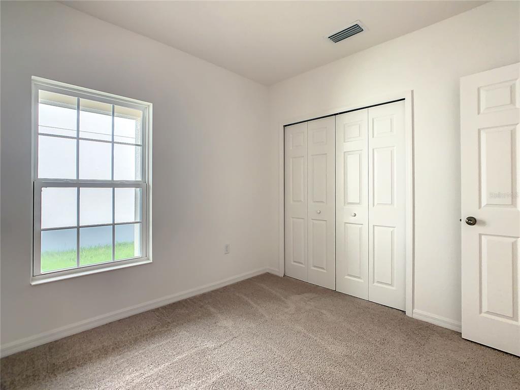 1761 Tree Shade Drive Davenport, FL 33837 - Photo 17 of 20 an empty room with windows and closet