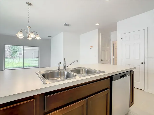 a kitchen with a sink and chandelier