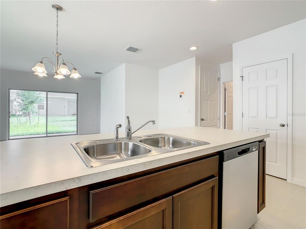 1761 Tree Shade Drive Davenport, FL 33837 - Photo 5 of 20 a kitchen with a sink and chandelier