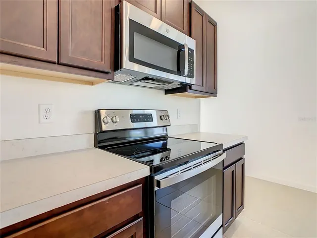 a kitchen with wooden cabinets and a stove top oven
