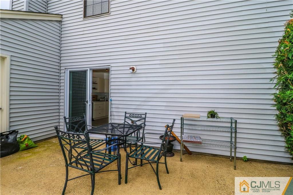 2901 Stonehedge Road, Unit 2901 Edison, NJ 08820 - Photo 22 of 25 a view of a patio with a table and chairs and potted plants