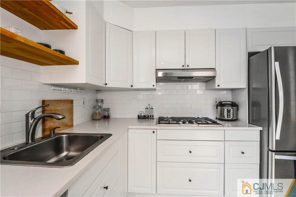 2901 Stonehedge Road, Unit 2901 Edison, NJ 08820 - Photo 8 of 25 a kitchen with stainless steel appliances granite countertop a sink stove and refrigerator