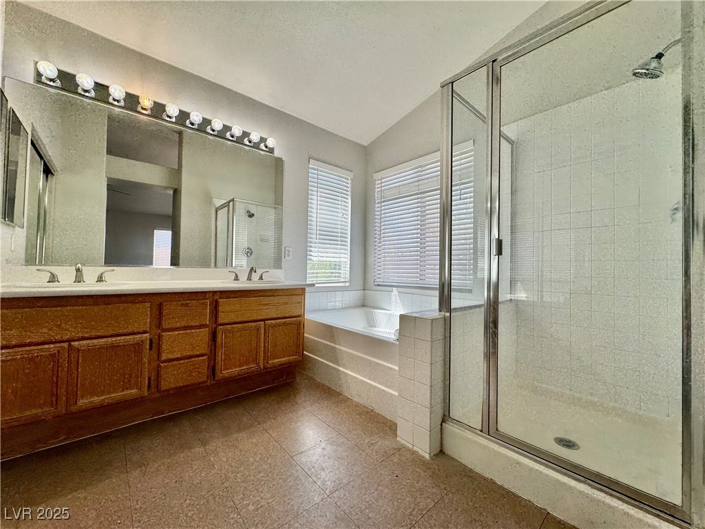 1828 Badger Canyon Avenue North Las Vegas, NV 89031 - Photo 12 of 14 Bathroom with vaulted ceiling, a bath, double vani