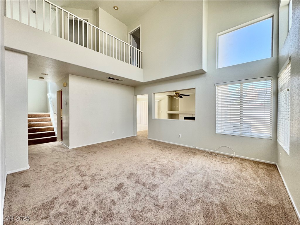 1828 Badger Canyon Avenue North Las Vegas, NV 89031 - Photo 2 of 14 Unfurnished living room featuring a towering ceili