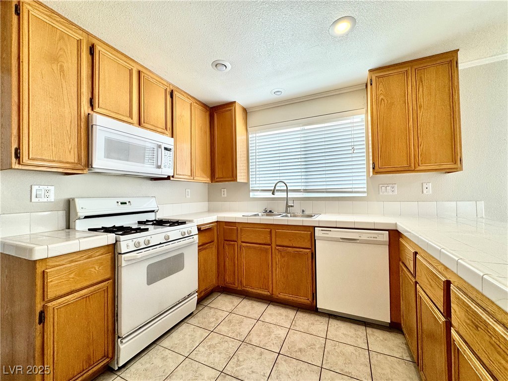 1828 Badger Canyon Avenue North Las Vegas, NV 89031 - Photo 5 of 14 Kitchen featuring white appliances, a textured cei