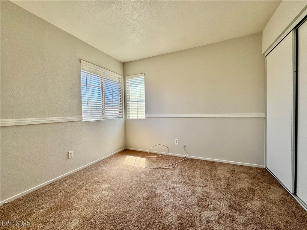 1828 Badger Canyon Avenue North Las Vegas, NV 89031 - Photo 7 of 14 Unfurnished bedroom with carpet, a textured ceilin