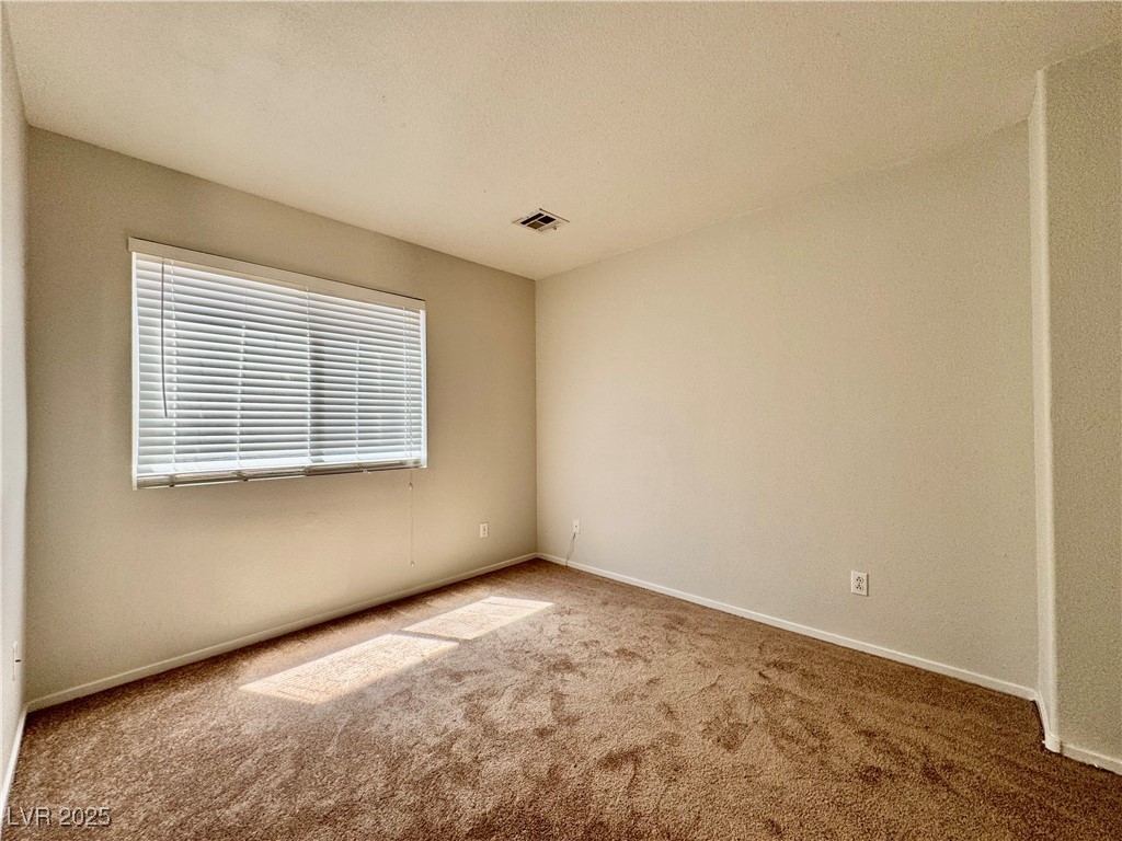 1828 Badger Canyon Avenue North Las Vegas, NV 89031 - Photo 10 of 14 Empty room featuring carpet and a textured ceiling