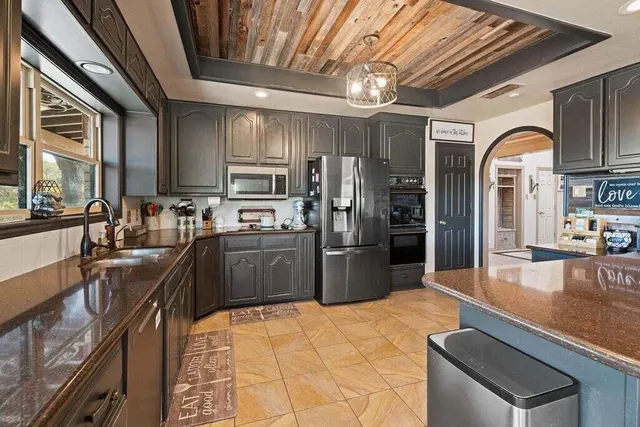 a kitchen with granite countertop a sink stove and refrigerator