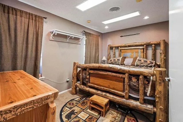 a view of a patio with couches table and chairs with wooden fence and large trees