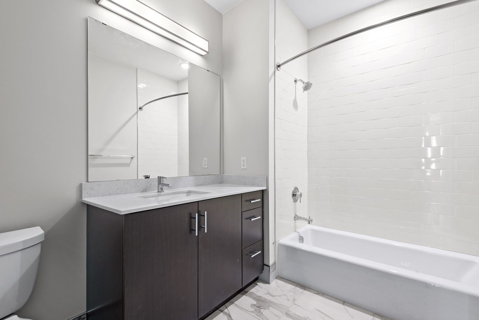 555 Roger Williams Avenue, Unit 405 Highland Park, IL 60035 - Photo 6 of 12 a bathroom with a granite countertop sink a toilet and shower