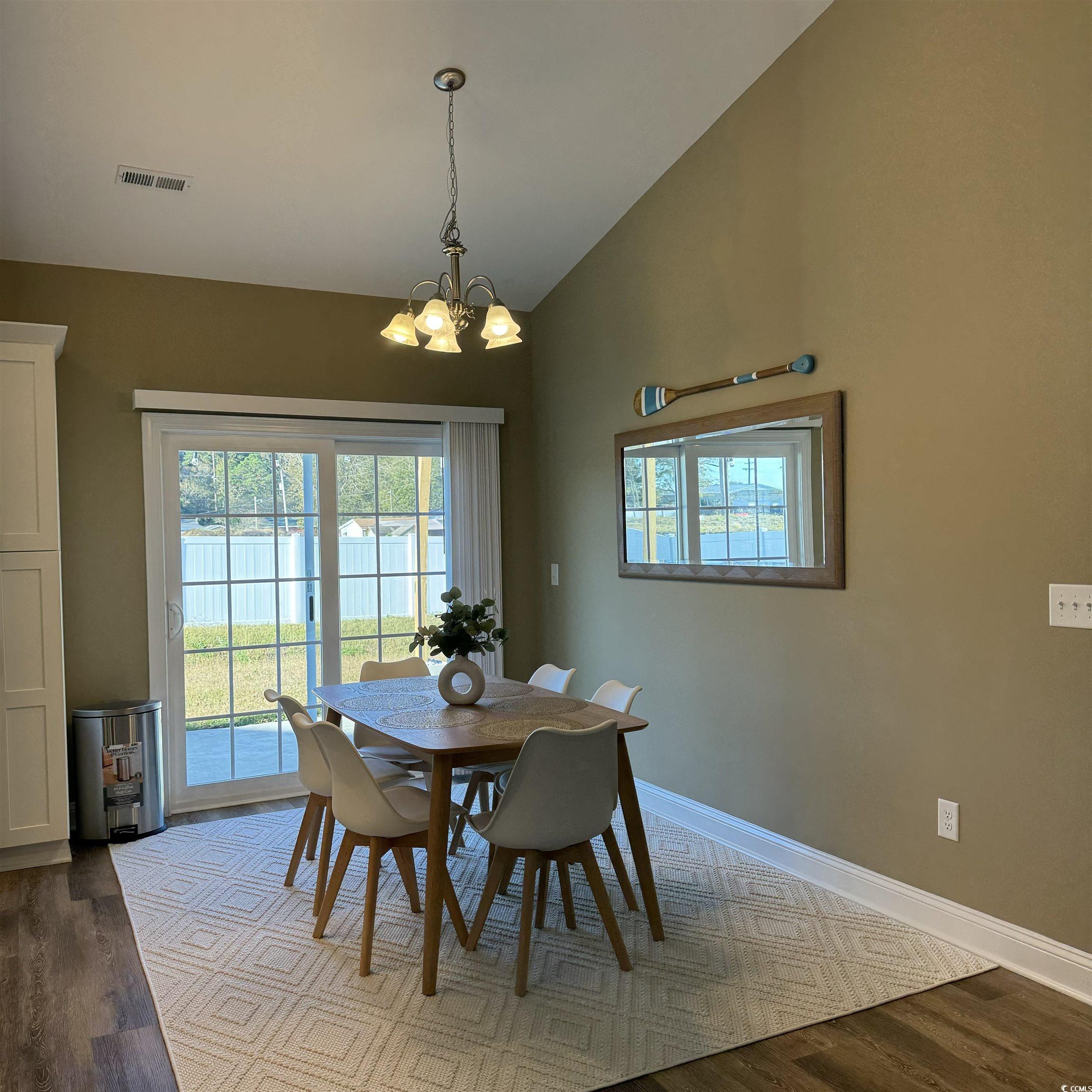 633 11th Avenue South Myrtle Beach, SC 29577 - Photo 13 of 25 Dining room with wood finished floors, a chandelier, and high vaulted ceiling