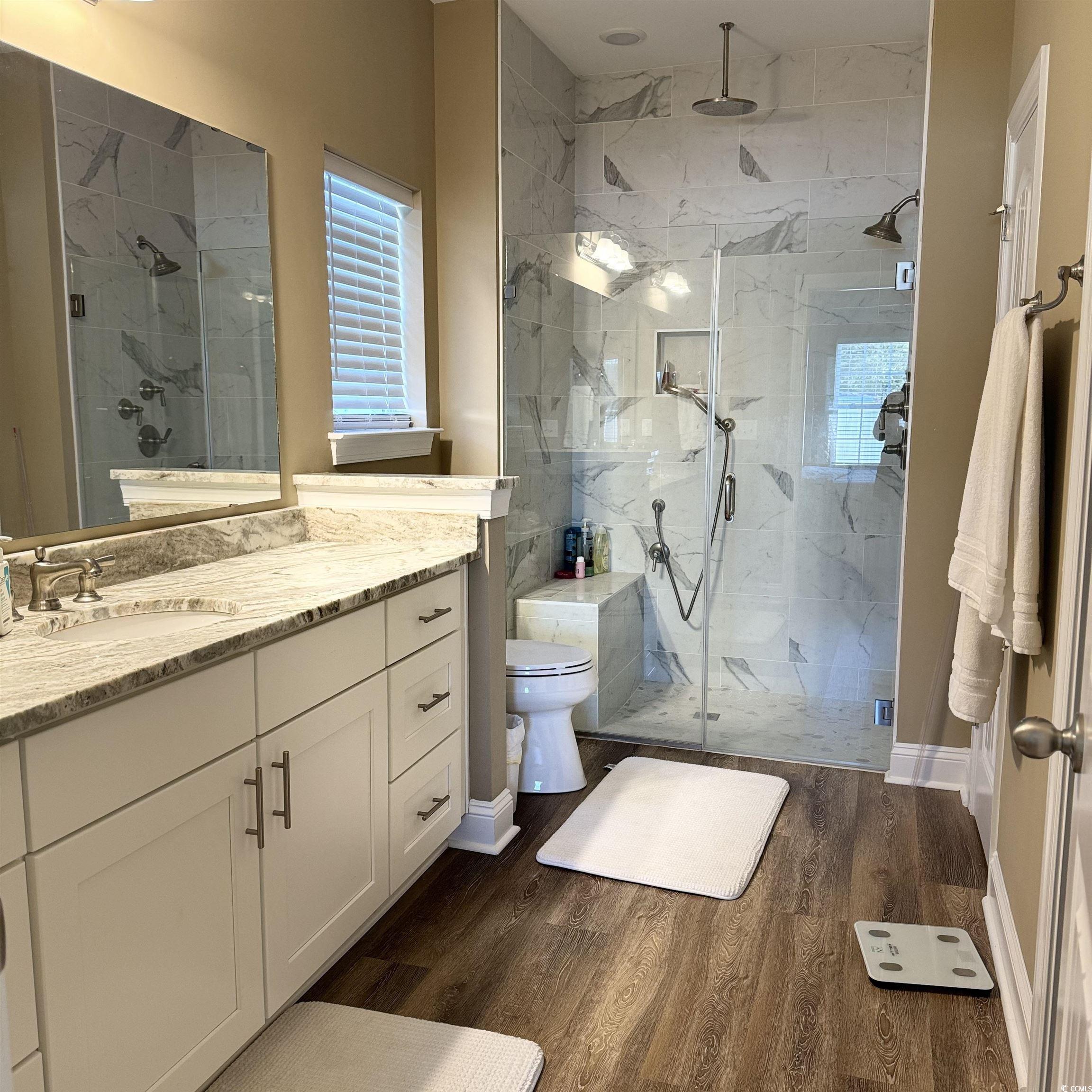 633 11th Avenue South Myrtle Beach, SC 29577 - Photo 18 of 25 Bathroom with vanity, a marble finish shower, and dark wood-style floors