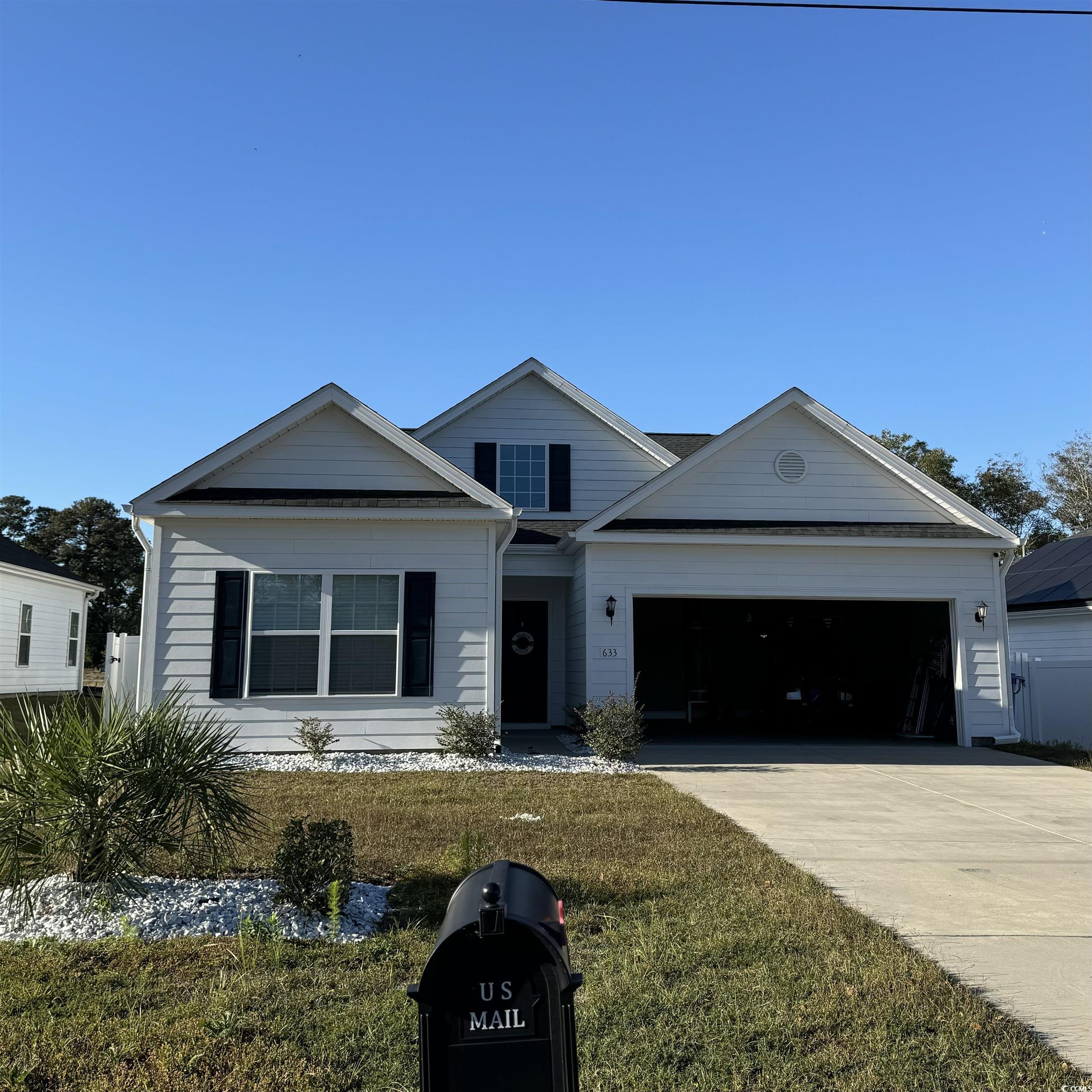 633 11th Avenue South Myrtle Beach, SC 29577 - Photo 3 of 25 View of front of property featuring concrete driveway, a front lawn, and an attached garage