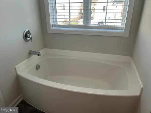 a white bath tub sitting in a bathroom next to a window