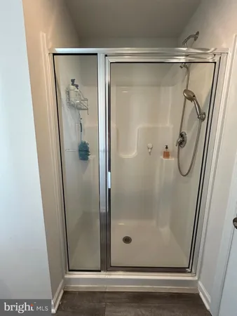 a bathroom with a glass shower door and a window