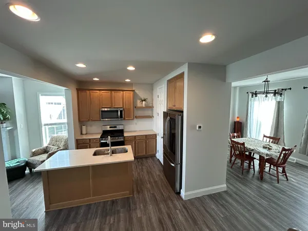 a kitchen view with a dining table chairs wooden floor and appliances