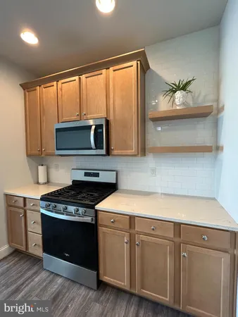 a kitchen with stainless steel appliances granite countertop a stove a sink and a microwave