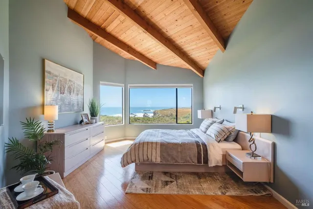 a spacious bedroom with a bed a couch and potted plant