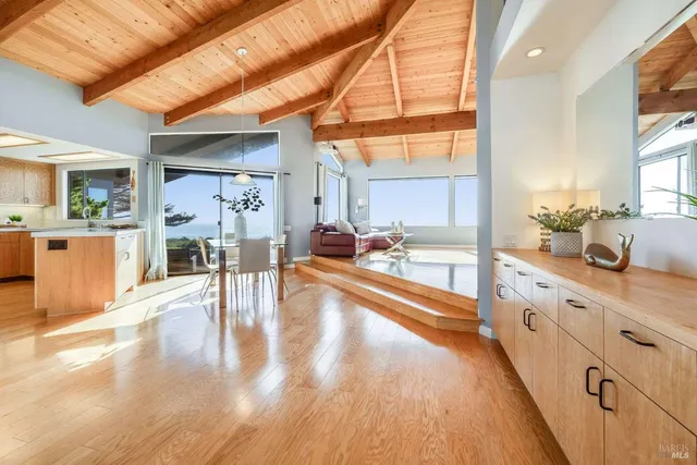 a large white kitchen with wooden floor