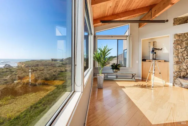 a view of a balcony with floor to ceiling windows with wooden floor