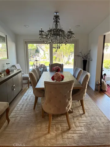 a dining room with furniture a chandelier and wooden floor