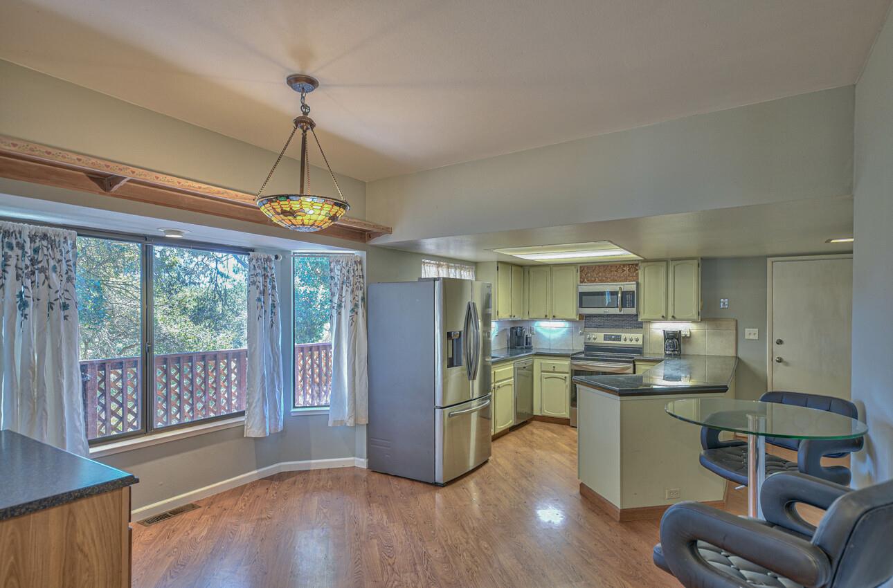 19205 Marjorie Road Salinas, CA 93907 - Photo 7 of 30 a kitchen with stainless steel appliances granite countertop a refrigerator a stove a sink dishwasher a dining table and chairs with wooden floor